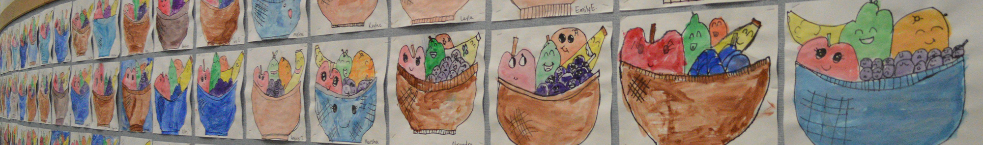 multiple student fruit basket artwork pieces displayed on the bulletin board