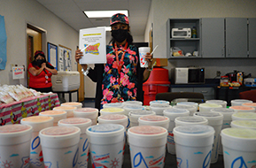 female teacher standing behind a cart of donated sonic drinks